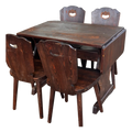 Dark wooden drop-leaf dining table with four chairs