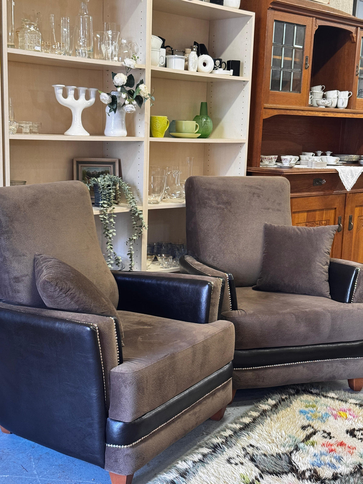 Pair of taupe upholstered armchairs with black side panels