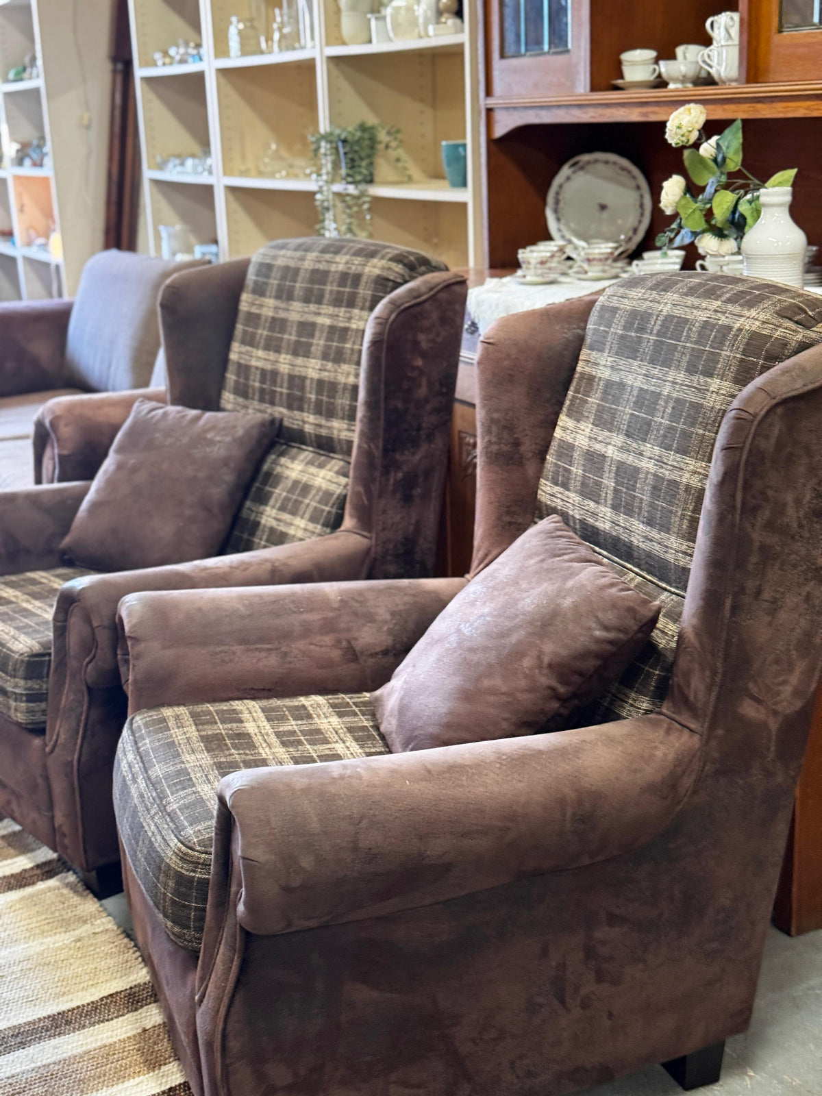 Pair of brown wingback armchairs with checked upholstery