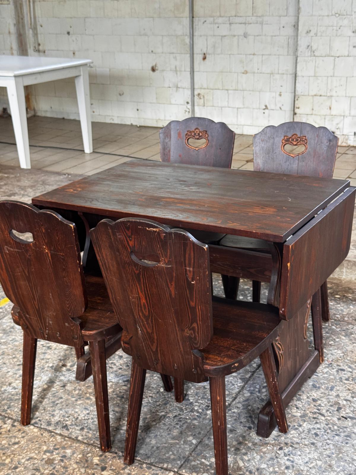 Dark wooden drop-leaf dining table with four chairs