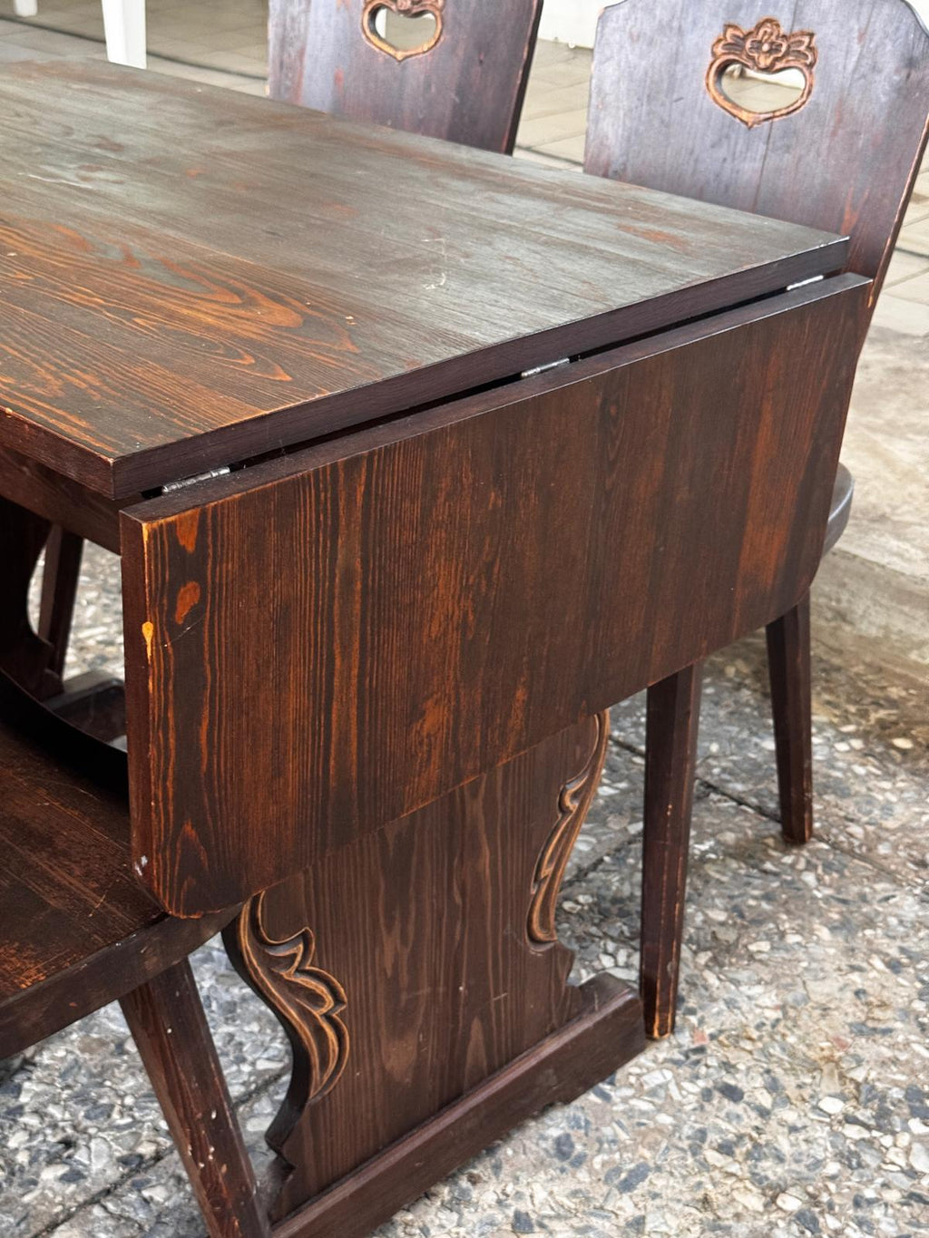 Dark wooden drop-leaf dining table with four chairs